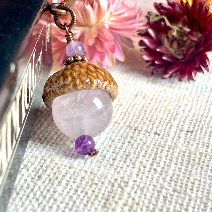 a close up of a key chain with flowers in the background